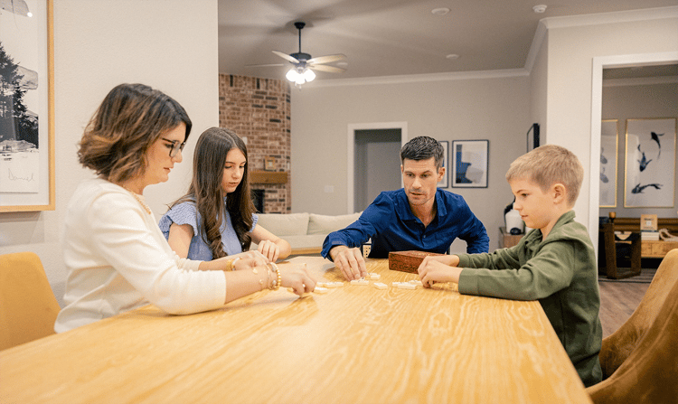 Photo of a family playing games at their dining table in a Betenbough home.