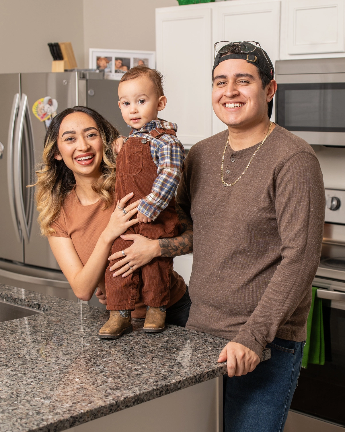 Adair-03640 Happy family of three smiling together within their kitchen.